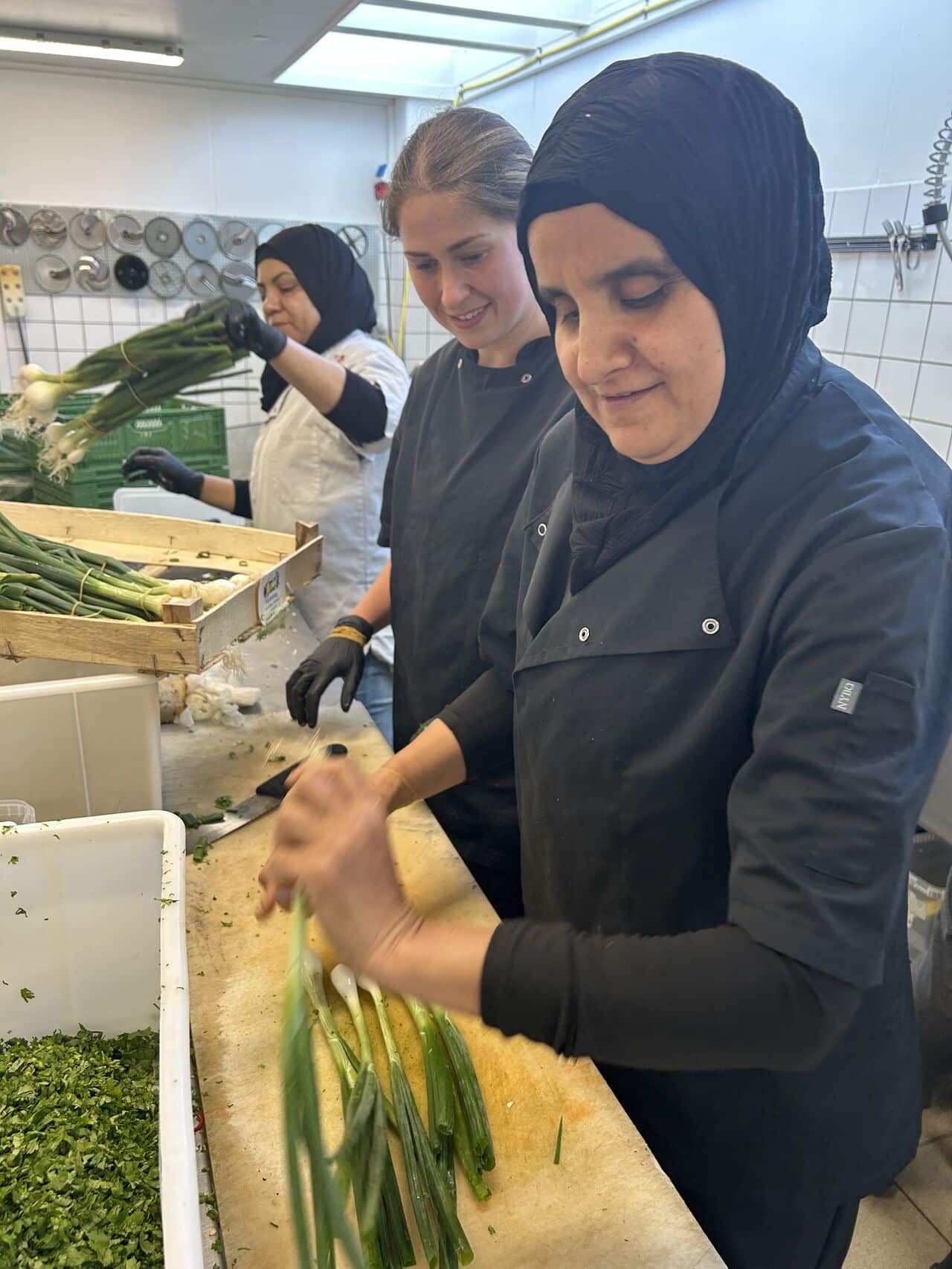 Gruppebillede af sociale ansættelser, som laver mad, hos virksomheden Mad Med Mest.